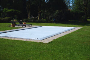 Bâche de piscine tendue conforme norme NF P90-308 et s'adapte parfaitement. Elle offre une finition bien plus esthétique qu'une bâche ou des lames rigides.