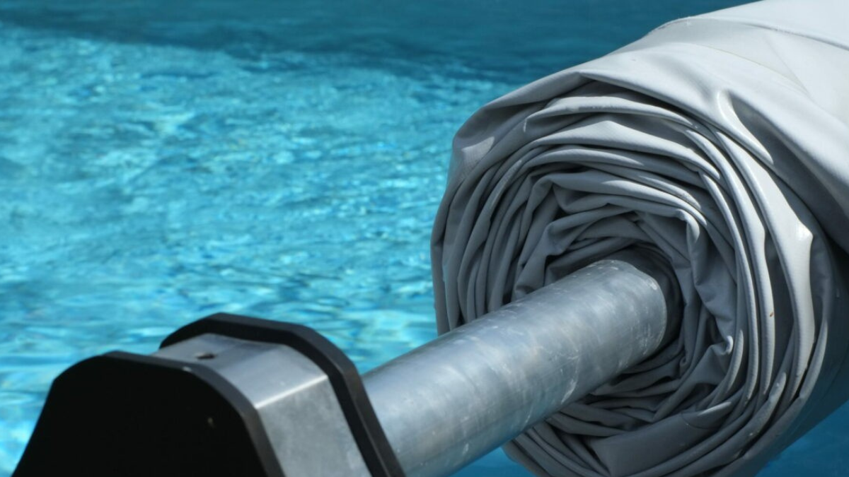 Enrouleur de couverture de piscine sur un bassin, facilitant la manipulation de la bâche.