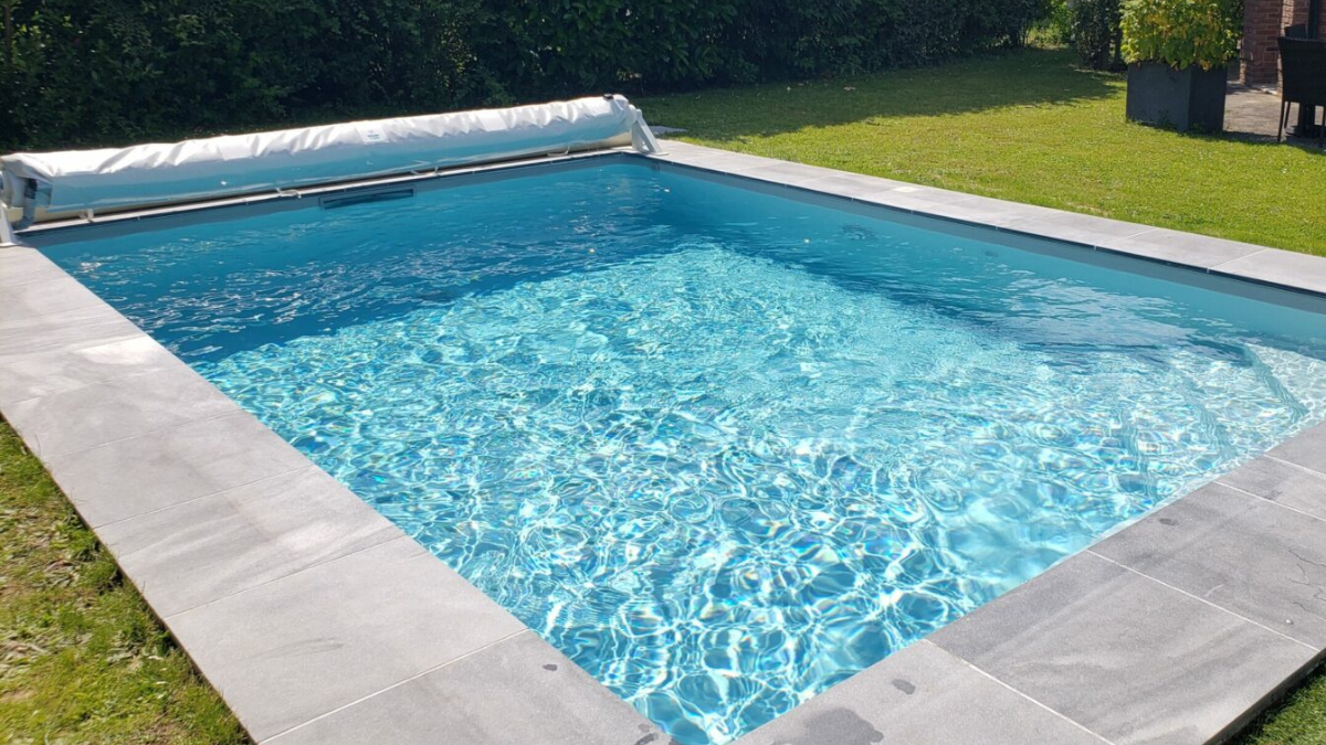Grande piscine bleu et sa couverture de piscine Koverloop